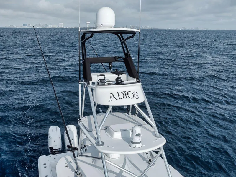 Slide: The Image of 2010 Bahama 41 boat named "Adios" on open sea with city skyline. - 30