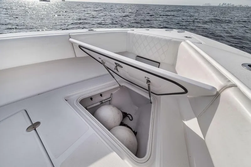 Slide: The Image of Open storage compartment on 2010 Bahama 41 boat, revealing fenders, with ocean in background. - 46