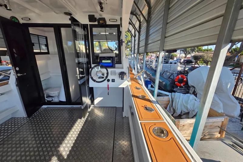 Slide: The Image of Interior of 2025 Custom Boat 34, featuring helm, controls, and dockside view. - 16