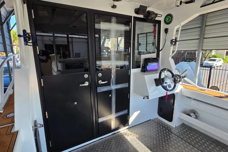 Slide: The Image of Interior of 2025 Custom Boat 34, featuring modern helm and sleek black doors. - 18