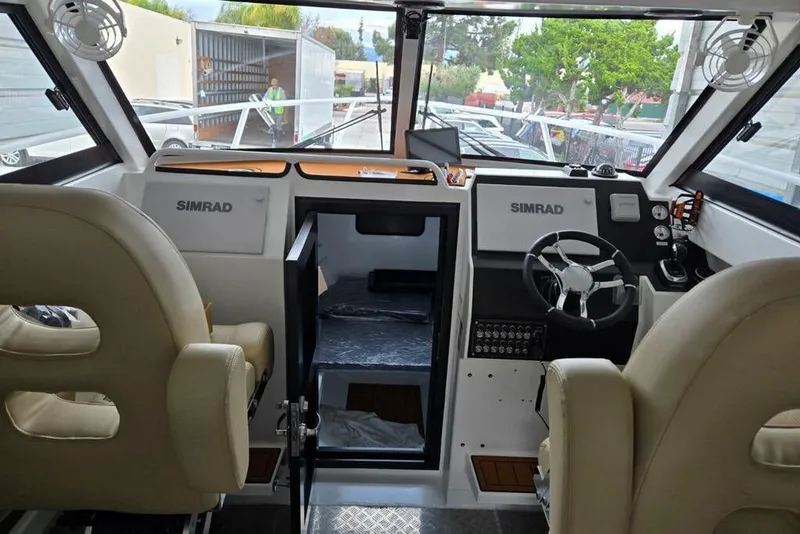 Slide: The Image of Interior of 2025 Custom Boat 34, featuring dual Simrad displays and comfortable seating. - 22