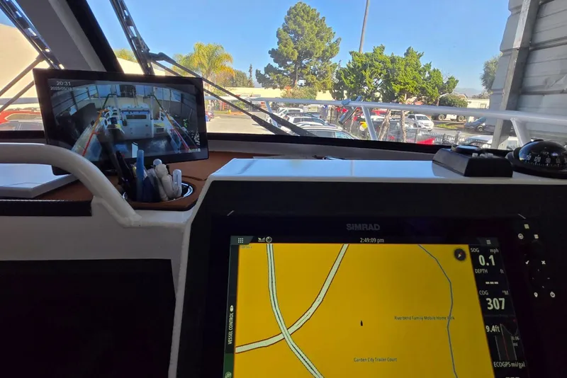 Slide: The Image of Interior view of a 2025 Custom Boat 34 with navigation screens and outdoor scenery. - 35