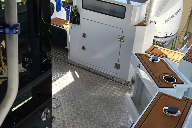 Slide: The Image of Interior of a 2025 Custom Boat 34 with Mercury engine, featuring aluminum flooring and storage compartments. - 37