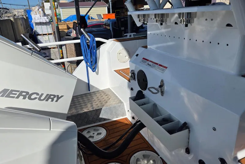 Slide: The Image of Custom Boat 34 (2025) with Mercury engine, featuring deck storage and blue rope. - 41