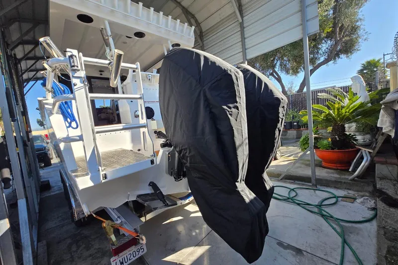 Slide: The Image of 2025 Custom Boat 34 with covered outboard motors in a sheltered area. - 44