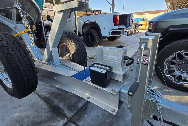 Slide: The Image of Trailer with Hydrastar brake actuator, Custom Boat 34, 2025 model, parked near trucks. - 47