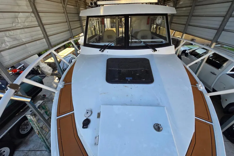 Slide: The Image of Custom Boat 34, 2025 model, docked in a covered storage area. - 6