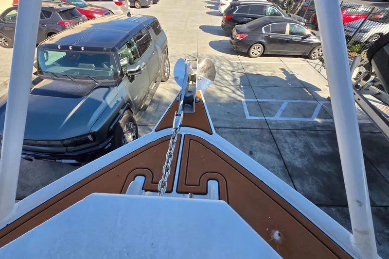 Slide: The Image of Bow view of 2025 Custom Boat 34 in parking lot, near vehicles. - 7