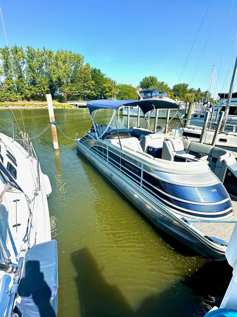 Slide: The Image of 2021 Bennington 25 QSB pontoon boat docked in marina. - 2