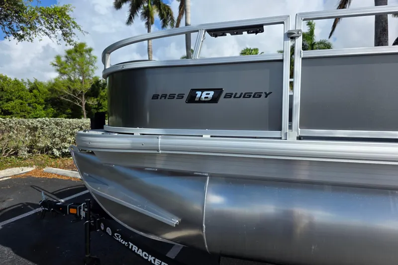 Slide: The Image of 2026 Sun Tracker Bass Buggy 16 XL Select pontoon boat, parked outdoors. - 4