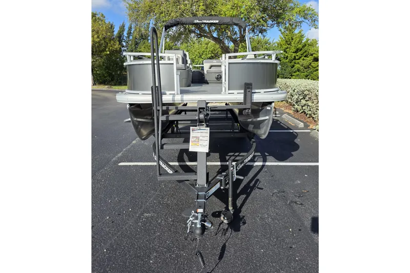 Slide: The Image of 2026 Sun Tracker Bass Buggy 16 XL Select pontoon boat on trailer in parking lot. - 9