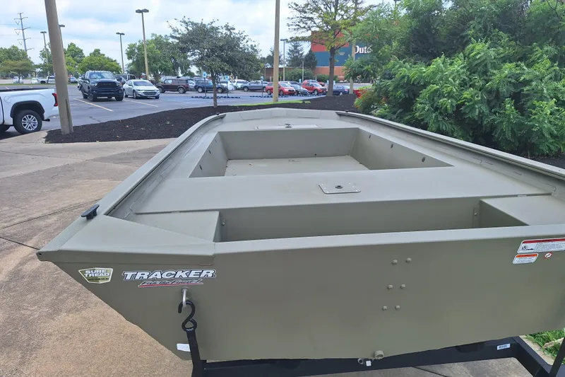 Slide: The Image of 2026 Tracker Grizzly 1754 Utility boat displayed outdoors in a parking lot setting. - 4