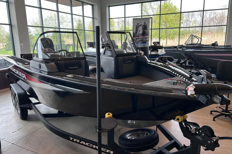 The Image of 2026 Tracker Targa V-19 Combo boat displayed indoors, featuring sleek black design and modern equipment. - 0