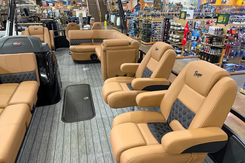 Slide: The Image of 2026 Ranger 223FC boat interior with tan and black seating in a showroom. - 3
