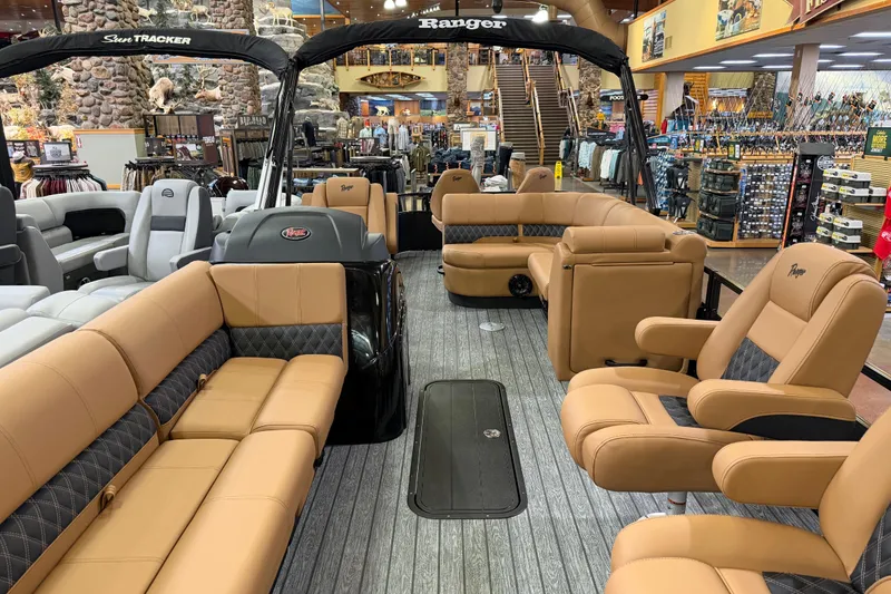 Slide: The Image of 2026 Ranger 223FC boat interior with tan seating, displayed in a showroom. - 4