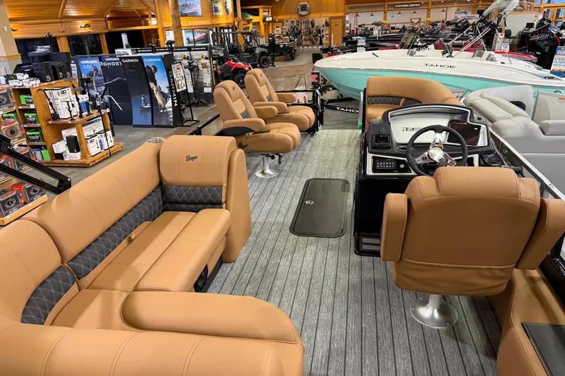 Slide: The Image of 2026 Ranger 223FC boat interior with tan seating and modern dashboard in showroom. - 7