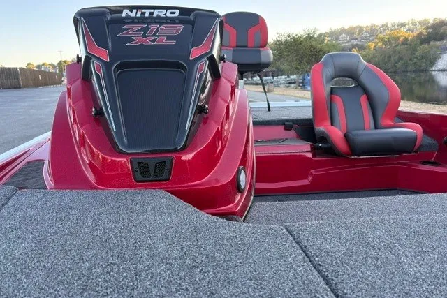 Slide: The Image of 2026 Nitro Z19 XL Pro boat with red and black seating, docked by a scenic lake. - 31