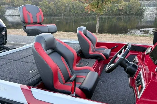 Slide: The Image of 2026 Nitro Z19 XL Pro boat interior with red and black seats by a riverside. - 41