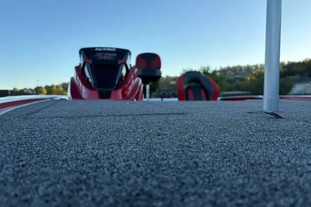 Slide: The Image of 2026 Nitro Z19 XL Pro boat deck with red seats and motor, under clear blue sky. - 25