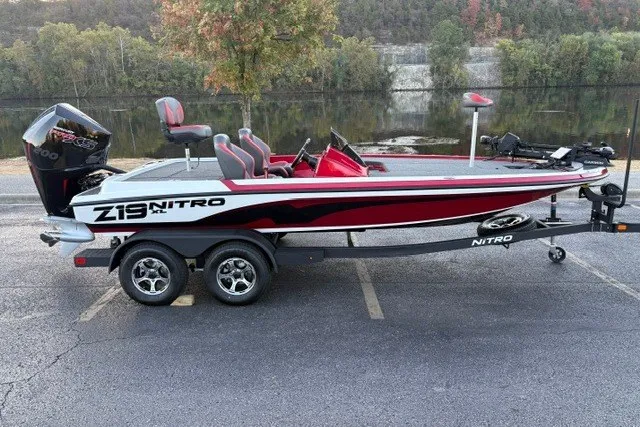 Slide: The Image of 2026 Nitro Z19 XL Pro boat on trailer, parked by a scenic lake. - 2