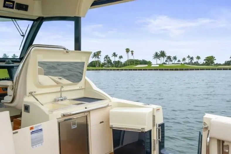 Slide: The Image of 2023 Chris-Craft Calypso 35 boat interior with water and palm trees in the background. - 10