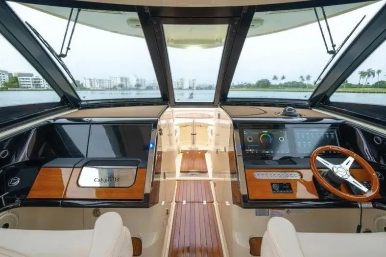 Slide: The Image of 2023 Chris-Craft Calypso 35 yacht interior with modern dashboard and wooden accents. - 12