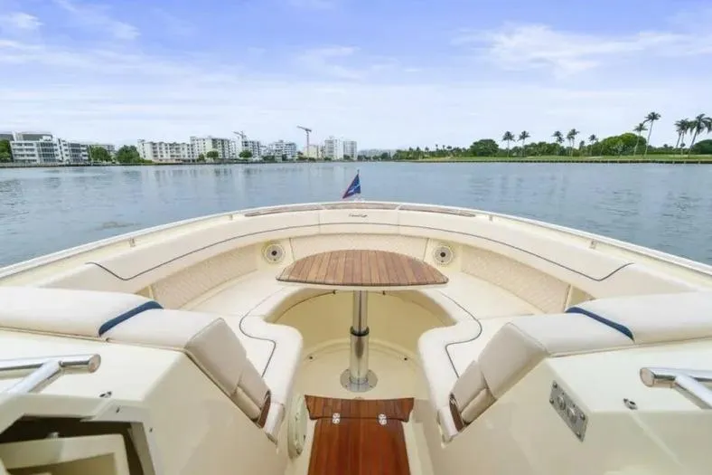 Slide: The Image of 2023 Chris-Craft Calypso 35 boat interior with waterfront view, featuring elegant seating and table. - 16
