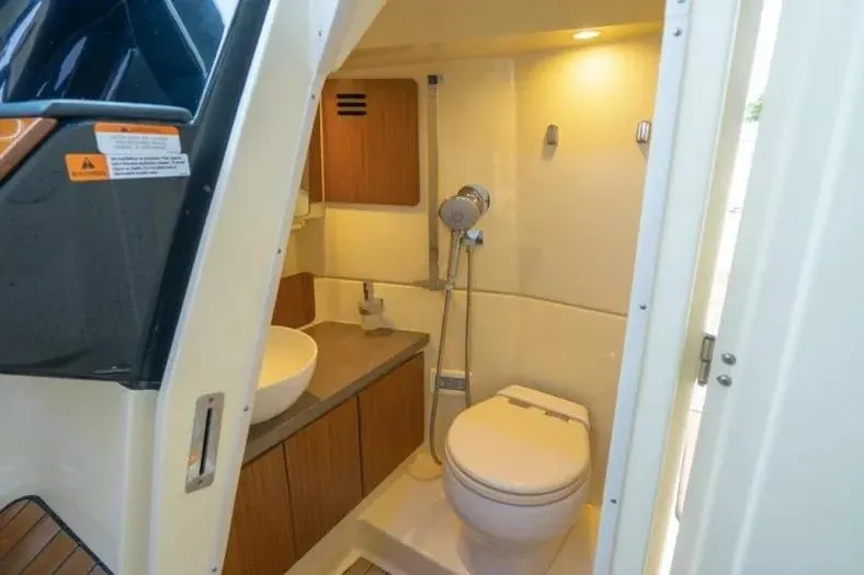 Slide: The Image of 2023 Chris-Craft Calypso 35 boat bathroom with modern fixtures and wooden cabinetry. - 24