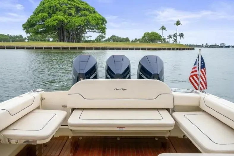 Slide: The Image of 2023 Chris-Craft Calypso 35 boat with triple Mercury engines on a serene lake. - 6