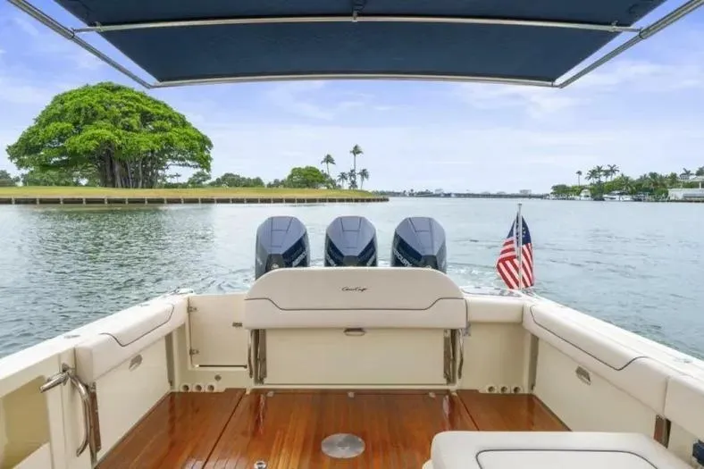 Slide: The Image of 2023 Chris-Craft Calypso 35 boat with triple engines, cruising on a scenic waterway. - 7