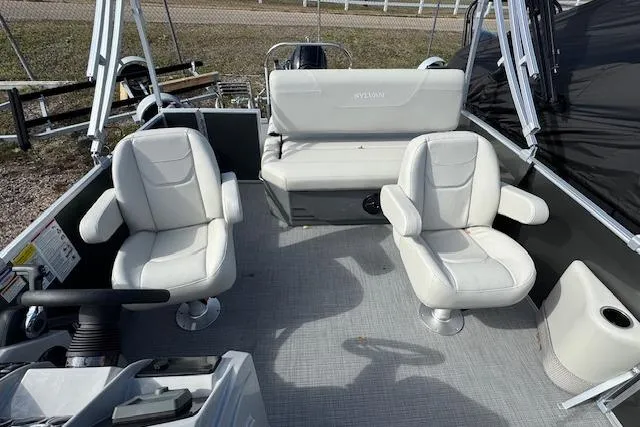 Slide: The Image of 2026 Sylvan 822 Mirage Cruise boat interior with white seating and steering console. - 11