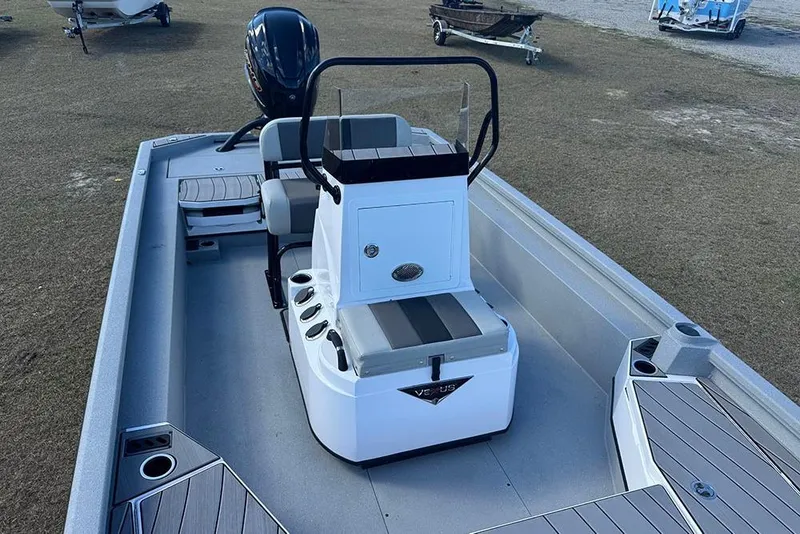 Slide: The Image of 2026 Vexus ACX 2210 boat interior with seating and console, parked on grass. - 22