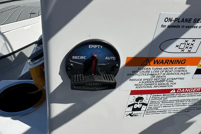Slide: The Image of Livewell control panel and warning labels on 2026 Vexus ACX 2210 boat. - 34