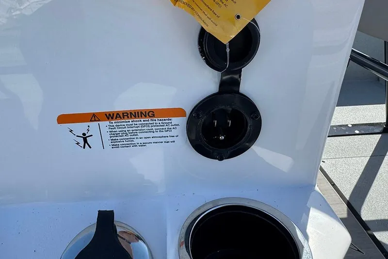 Slide: The Image of 2026 Vexus ACX 2210 boat power outlet with warning label and protective cover. - 35