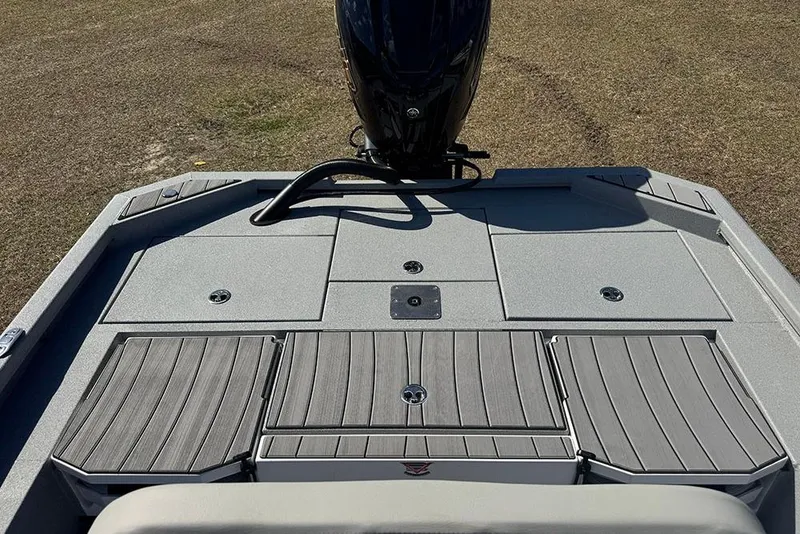 Slide: The Image of 2026 Vexus ACX 2210 boat deck with storage compartments and motor, on grassy background. - 37