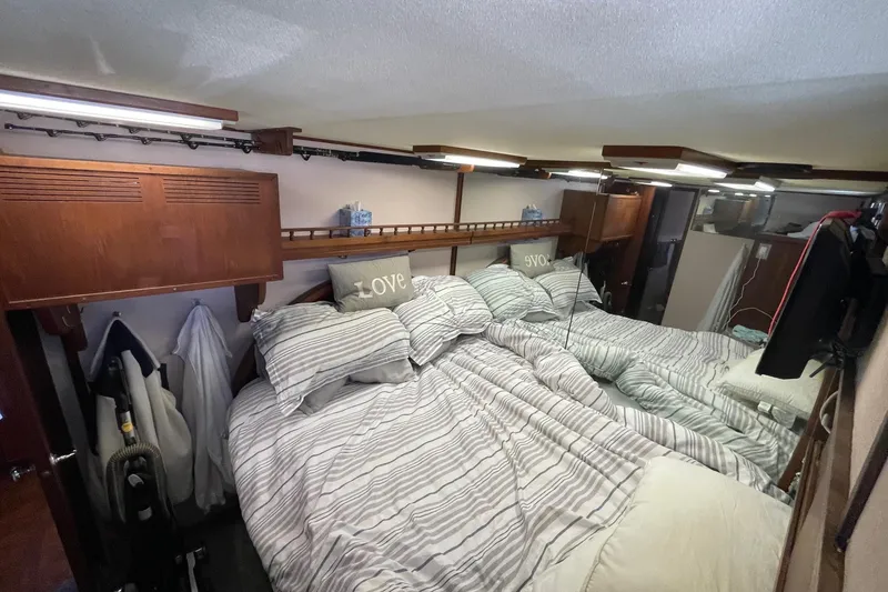 Slide: The Image of 1975 Uniflite Sport Fisher 42 cabin with cozy striped bedding and wooden accents. - 17