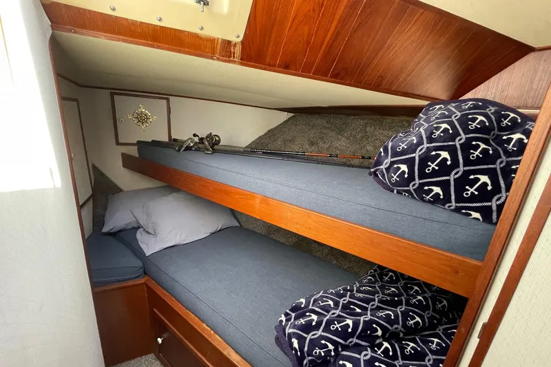 Slide: The Image of 1975 Uniflite Sport Fisher 42 cabin with cozy bunk beds and nautical-themed decor. - 19