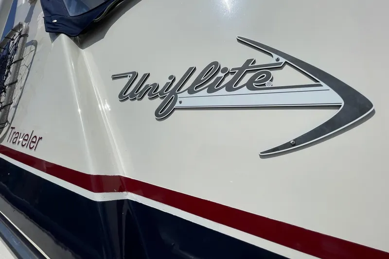Slide: The Image of 1975 Uniflite Sport Fisher 42 boat with logo and red-blue stripe design. - 2