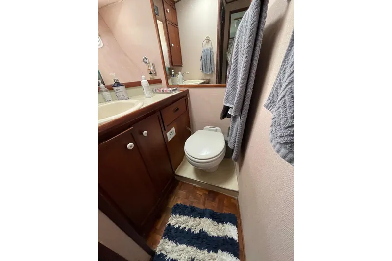 Slide: The Image of 1975 Uniflite Sport Fisher 42 bathroom with wooden cabinets and nautical decor. - 20
