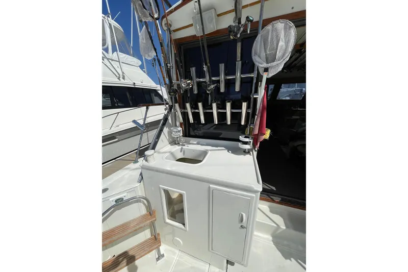 Slide: The Image of 1975 Uniflite Sport Fisher 42 fishing gear setup with rods and net on deck. - 23