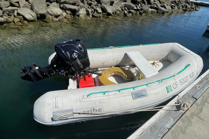 Slide: The Image of Inflatable boat with Tohatsu motor docked by rocky shore, 1975 Uniflite Sport Fisher 42. - 29