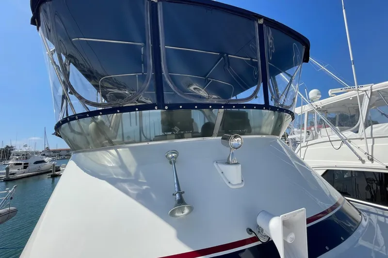 Slide: The Image of 1975 Uniflite Sport Fisher 42 boat with blue canopy, docked in a marina. - 6
