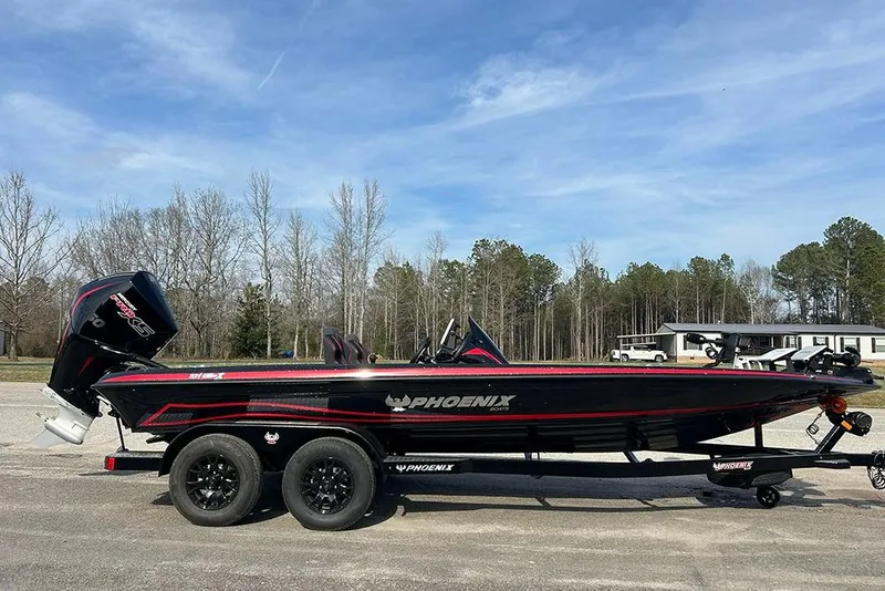 The Image of 2026 Phoenix 921 Elite X boat on trailer, parked outdoors under clear sky. - 0