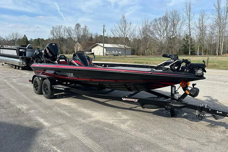 Slide: The Image of 2026 Phoenix 921 Elite X boat on trailer, parked outdoors on a sunny day. - 2