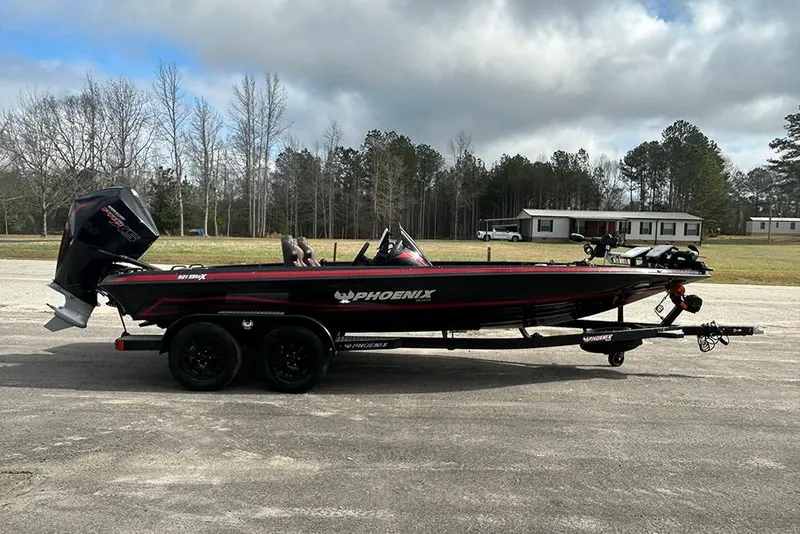 Slide: The Image of 2026 Phoenix 921 Elite X boat on trailer, parked outdoors with cloudy sky. - 6