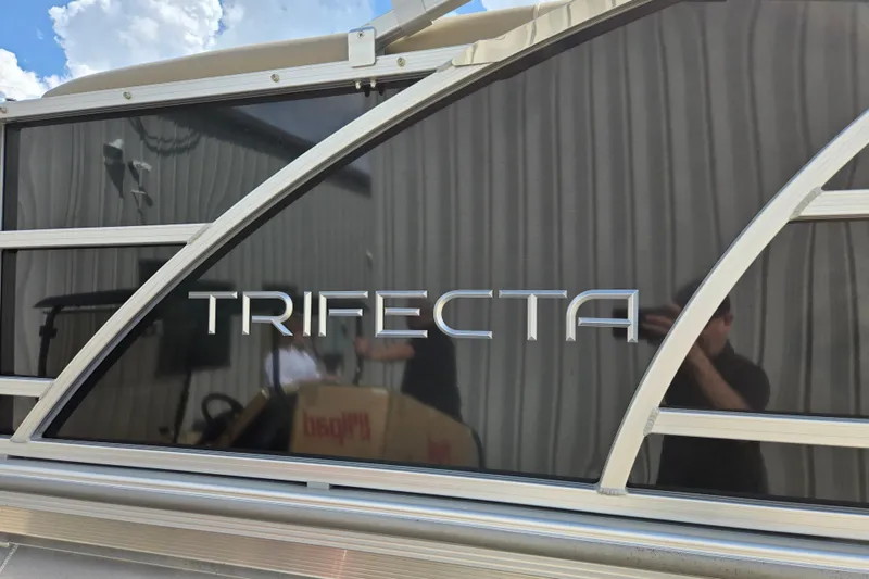 Slide: The Image of 2021 Trifecta SS 23C 2.75 pontoon boat with sleek design and reflective surface. - 11
