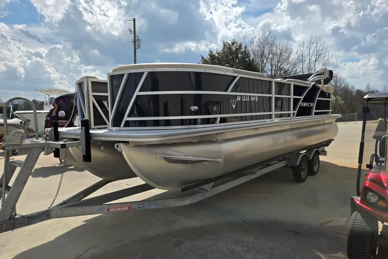 Slide: The Image of 2021 Trifecta SS 23C 2.75 pontoon boat on trailer under cloudy sky. - 9