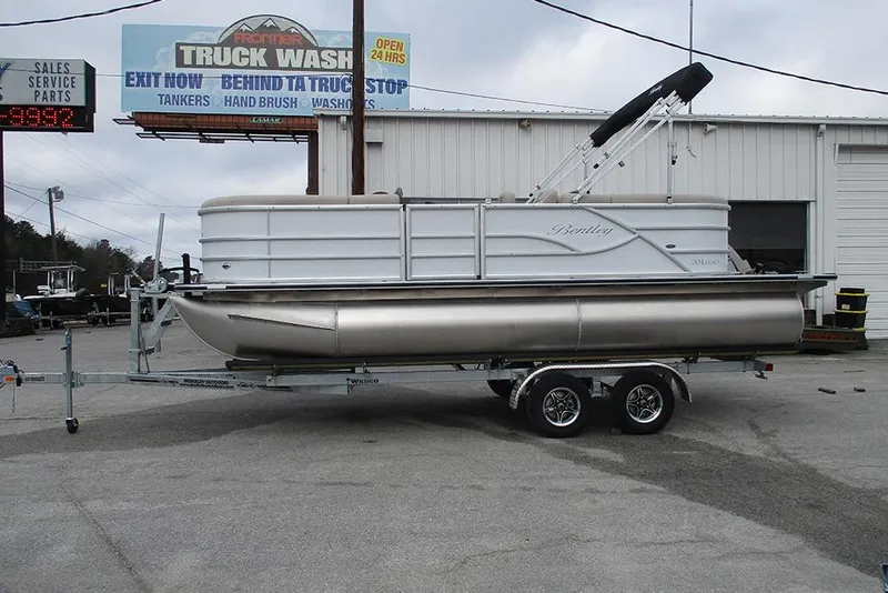 The Image of 2026 Bentley Pontoons Legacy 200 Navigator on trailer, parked near a truck wash. - 1