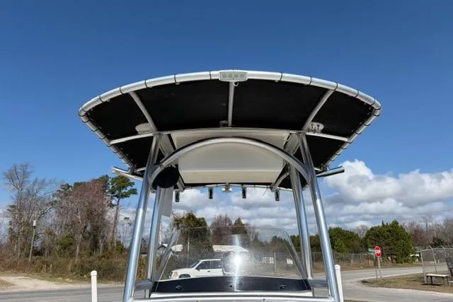 Slide: The Image of 2015 Sportsman Heritage 211 Center Console boat with T-top against blue sky. - 14