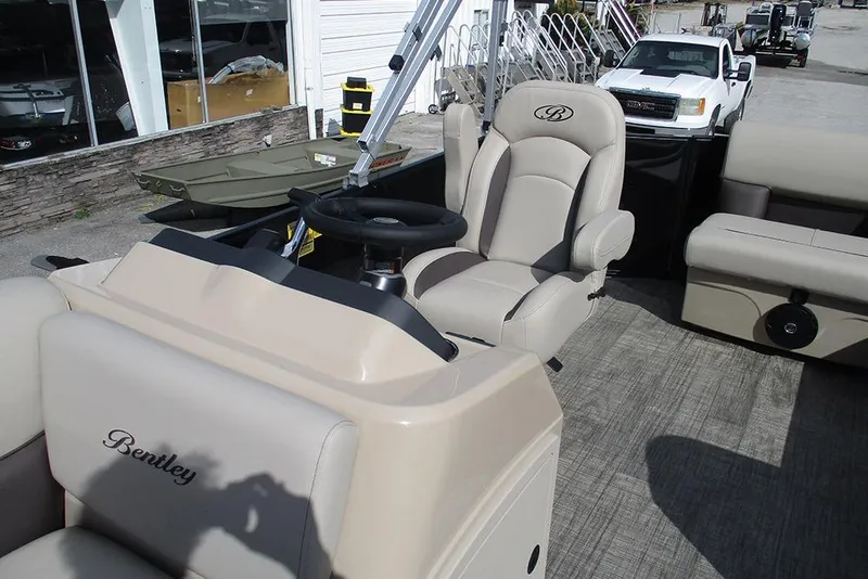 Slide: The Image of 2026 Bentley Pontoons LE 180 CR interior with beige seating and steering wheel. - 21